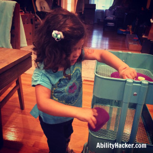 IKEA Raskog cart used by a child who wears AFOs and uses a walker to help clear the table by pushing items from table to the kitchen and vice versa