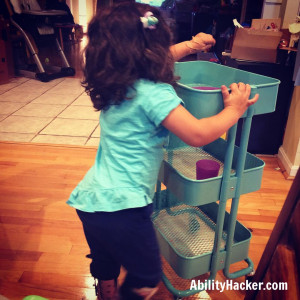 Child who wears AFOs pushing an IKEA Raskog cart to help clear the table