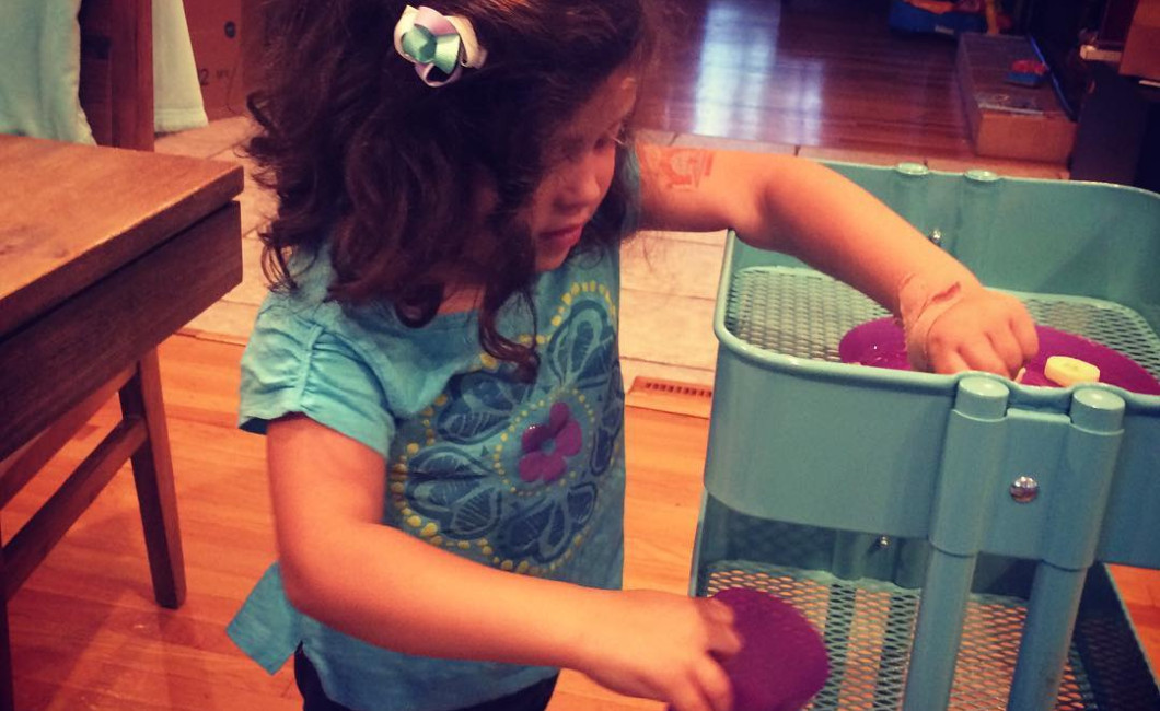 IKEA Raskog cart used by a child to help clear the table by pushing items from table to the kitchen and vice versa